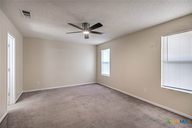 carpeted spare room with a textured ceiling and ceiling fan