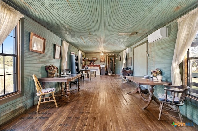 sunroom featuring a wall mounted air conditioner and ceiling fan