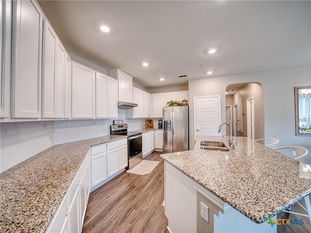 kitchen featuring an island with sink, appliances with stainless steel finishes, sink, and white cabinets