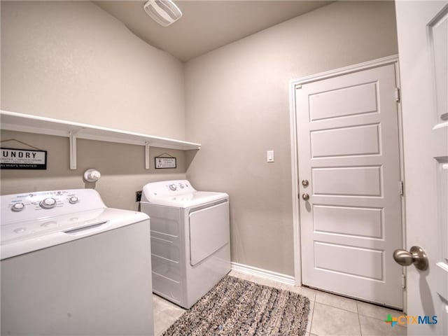 clothes washing area with independent washer and dryer and light tile patterned flooring