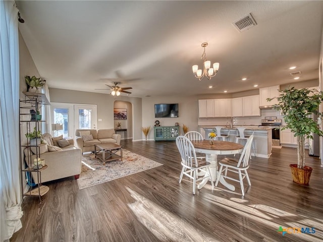 dining area featuring dark hardwood / wood-style flooring and ceiling fan with notable chandelier