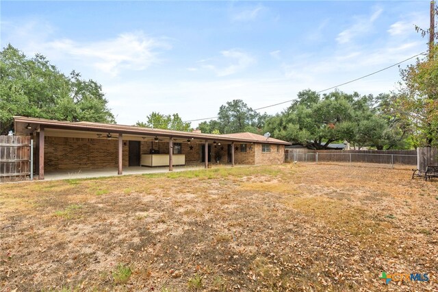 view of yard featuring ceiling fan and a patio