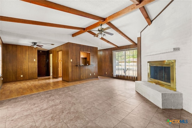 unfurnished living room featuring lofted ceiling with beams, ceiling fan, wood-type flooring, and a fireplace