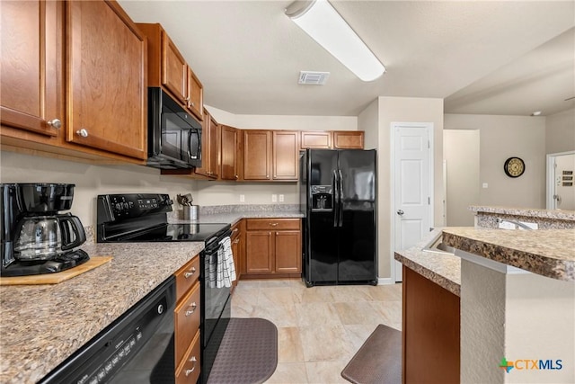 1212 Wethersfield Ln, Temple, TX 76504 - kitchen with black appliances, brown cabinets, and light countertops