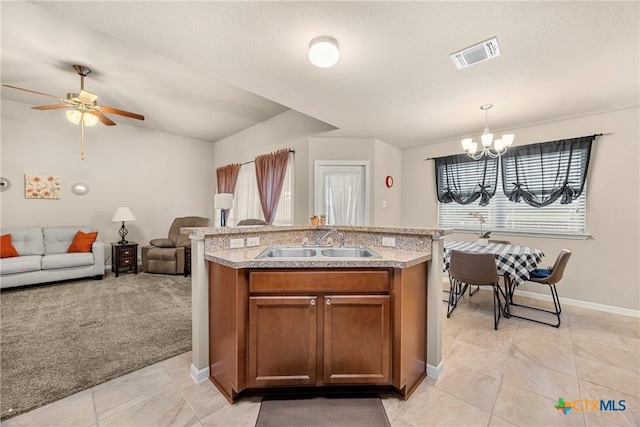 1212 Wethersfield Ln, Temple, TX 76504 - kitchen with a chandelier, brown cabinetry, open floor plan, light countertops, and hanging light fixtures