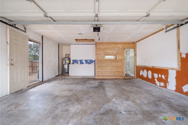 garage featuring a garage door opener, wooden walls, and water heater