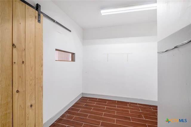 interior space with dark hardwood / wood-style floors and a barn door