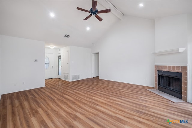 unfurnished living room with ceiling fan, light wood-type flooring, and a tile fireplace