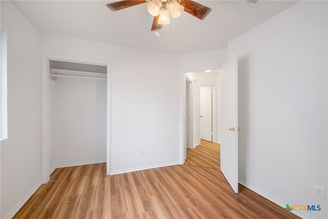 unfurnished bedroom featuring ceiling fan, light wood-type flooring, and a closet