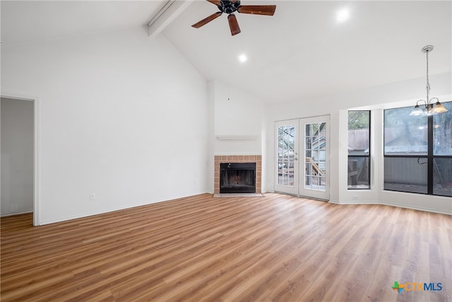 unfurnished living room with beamed ceiling, ceiling fan with notable chandelier, wood-type flooring, and high vaulted ceiling