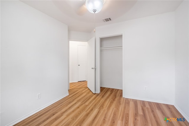 unfurnished bedroom featuring light hardwood / wood-style flooring, a closet, and ceiling fan