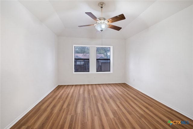 empty room featuring hardwood / wood-style floors, vaulted ceiling, and ceiling fan