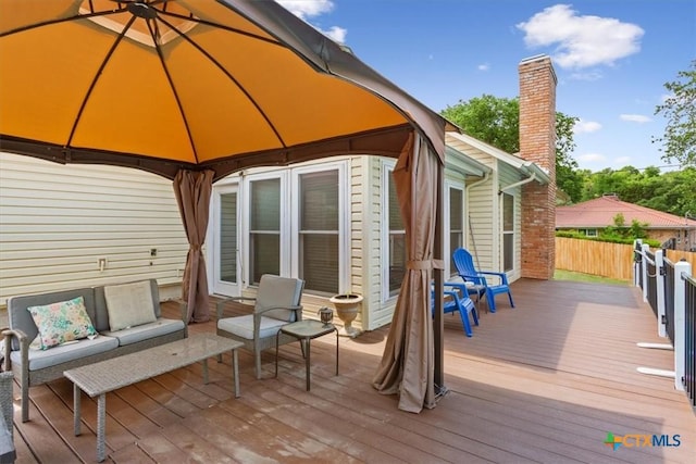 wooden terrace featuring a gazebo and outdoor lounge area