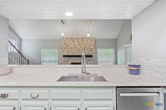 kitchen with dishwasher, a sink, backsplash, lofted ceiling, and white cabinetry