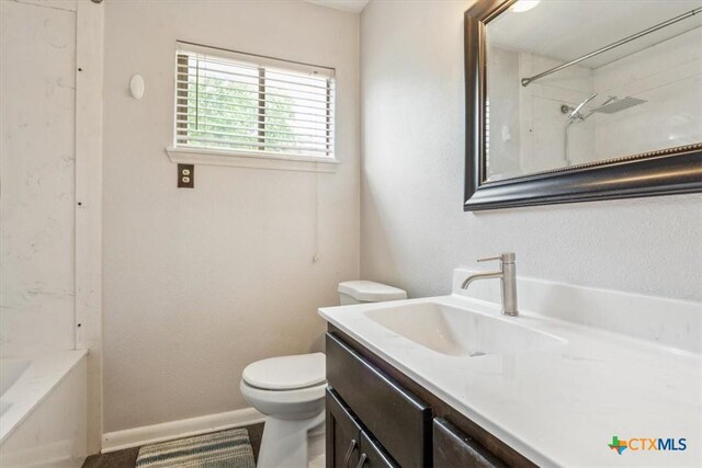 bathroom featuring toilet, vanity, and baseboards