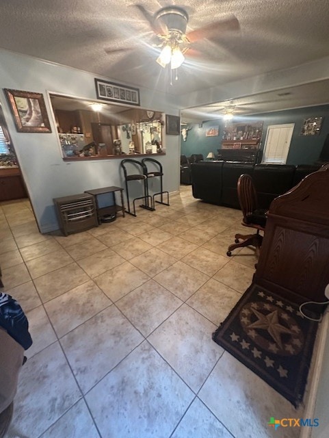 interior space featuring a ceiling fan and a textured ceiling