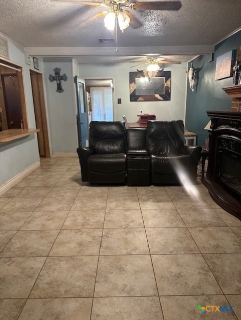 tiled living room with a ceiling fan, a textured ceiling, visible vents, and a fireplace