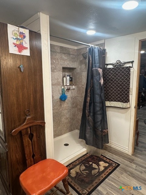 full bathroom with wood finished floors and a stall shower