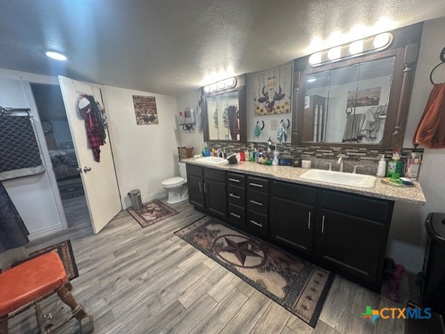 full bath with wood finished floors, a sink, and double vanity