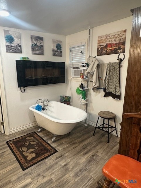 full bathroom with a freestanding bath, cooling unit, wood finished floors, and baseboards