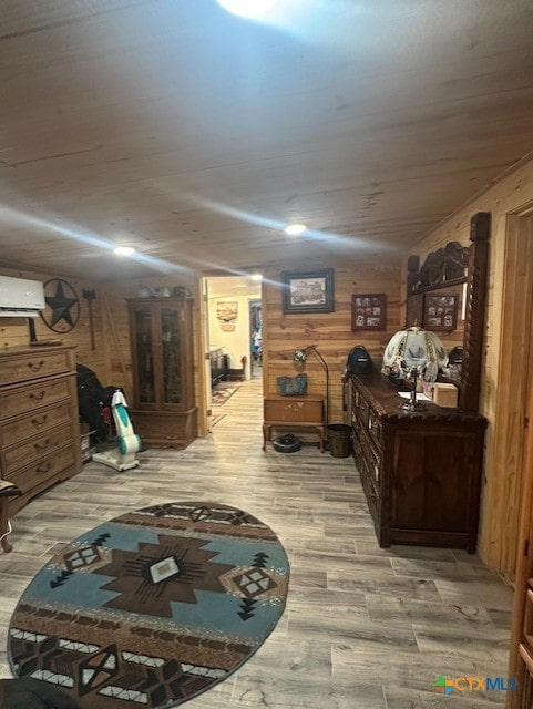 below grade area with a wall mounted AC, wooden walls, and light wood-type flooring