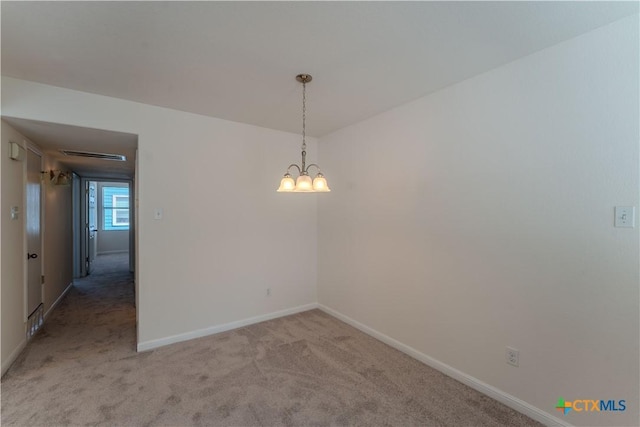 carpeted empty room with a chandelier