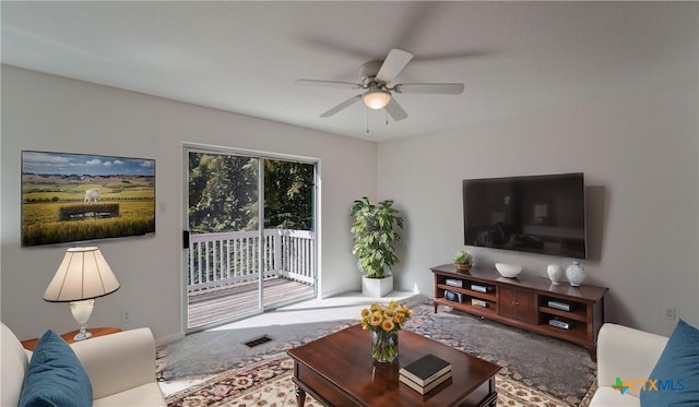 carpeted living room with ceiling fan