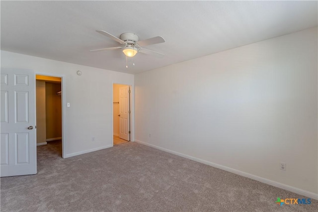 unfurnished bedroom with ceiling fan, light colored carpet, and a spacious closet