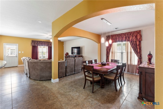 dining space with a wealth of natural light, ceiling fan, and tile patterned floors