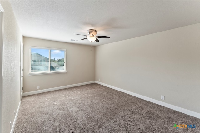 carpeted spare room featuring a textured ceiling and ceiling fan