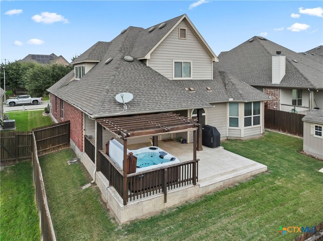 back of property with a hot tub, central air condition unit, a lawn, and a patio area