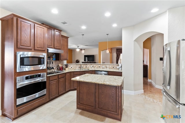 kitchen with backsplash, appliances with stainless steel finishes, hanging light fixtures, sink, and kitchen peninsula