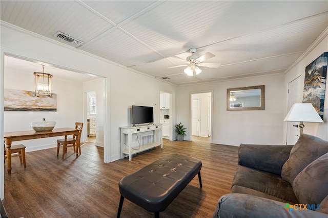 living room featuring ceiling fan with notable chandelier, dark hardwood / wood-style flooring, and crown molding