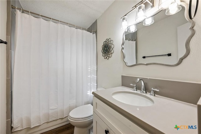 full bathroom with hardwood / wood-style floors, a textured ceiling, toilet, shower / bath combo with shower curtain, and vanity