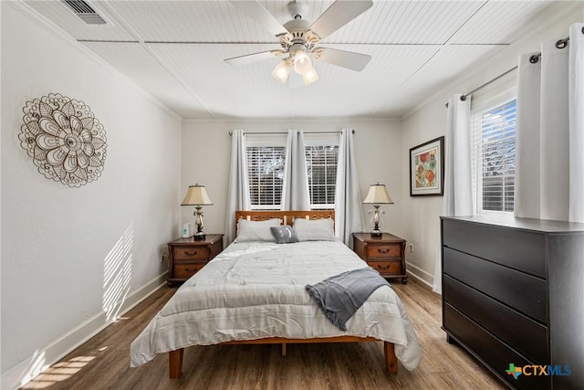 bedroom with wood-type flooring, ceiling fan, and ornamental molding