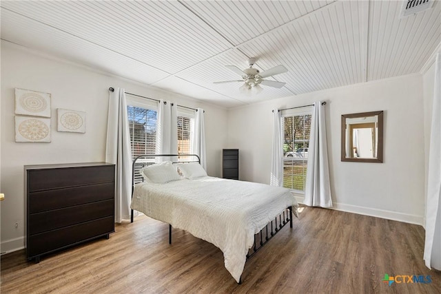 bedroom featuring wooden ceiling, ceiling fan, wood-type flooring, and multiple windows