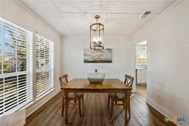 dining room featuring dark hardwood / wood-style floors, an inviting chandelier, and crown molding