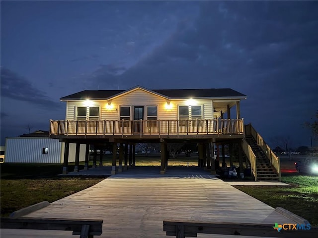 43 Buckskin Dr, Palacios, TX 77465 - back of house at twilight featuring a carport, stairs, and driveway