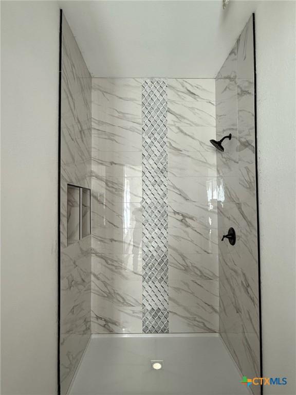 bathroom with toilet, vanity, and tiled shower