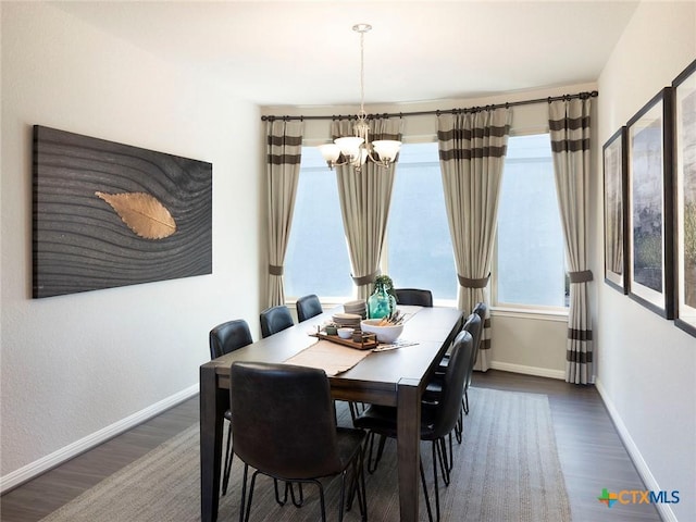 dining space featuring a notable chandelier, plenty of natural light, and dark hardwood / wood-style floors