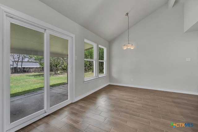 102 Montague Dr, Kyle, TX 78640 - unfurnished dining area with baseboards, wood finished floors, high vaulted ceiling, and a chandelier