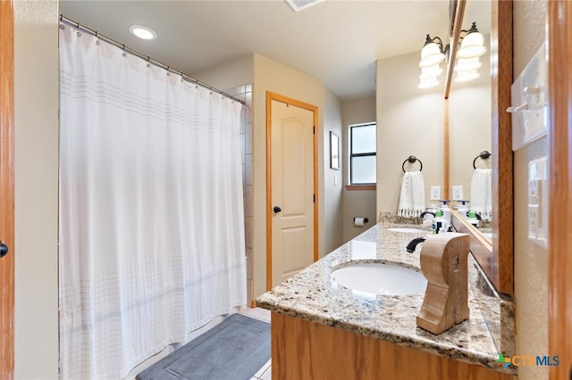 full bathroom featuring double vanity, visible vents, a sink, and a shower with shower curtain