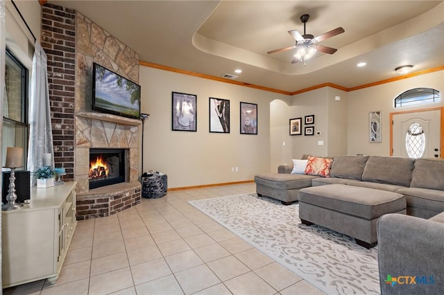 living area with arched walkways, light tile patterned floors, a raised ceiling, visible vents, and ornamental molding