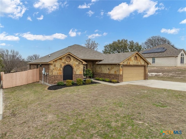 ranch-style home with an attached garage, fence, concrete driveway, stone siding, and a front yard