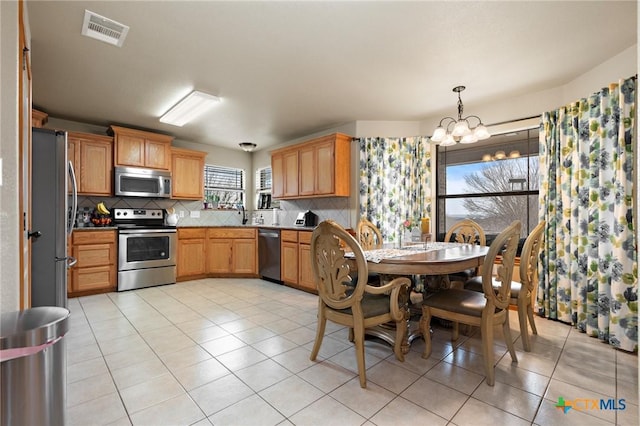 kitchen featuring appliances with stainless steel finishes, light tile patterned flooring, visible vents, and decorative backsplash