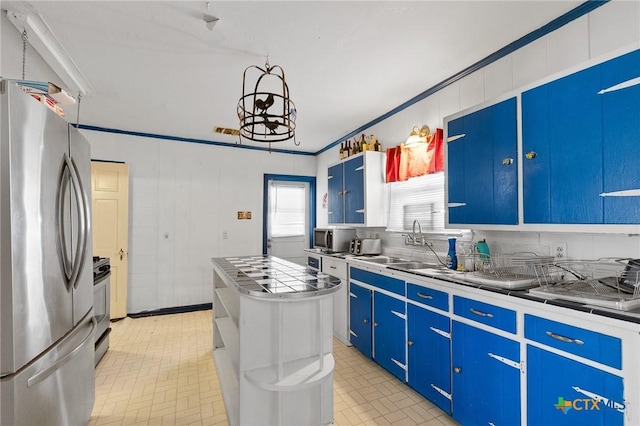 604 Westwood Dr, San Antonio, TX 78212 - kitchen with appliances with stainless steel finishes, blue cabinets, a sink, a chandelier, and light countertops