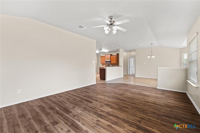 6208 Suellen Ln, Killeen, TX 76542 - unfurnished living room featuring vaulted ceiling, dark wood-type flooring, a ceiling fan, and a chandelier