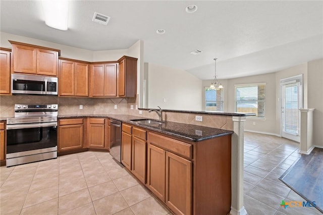 6208 Suellen Ln, Killeen, TX 76542 - kitchen with stainless steel appliances, a peninsula, brown cabinetry, light tile patterned floors, and backsplash