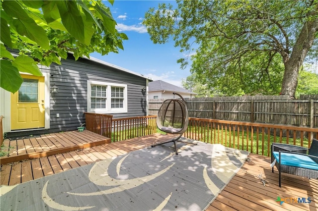 wooden terrace featuring a fenced backyard
