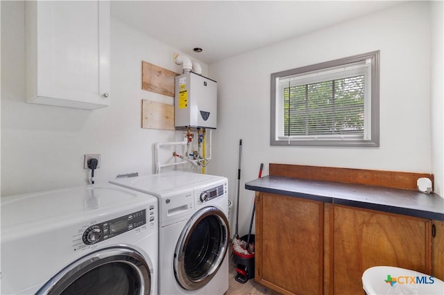 washroom with tankless water heater, washing machine and dryer, cabinet space, and wood finished floors